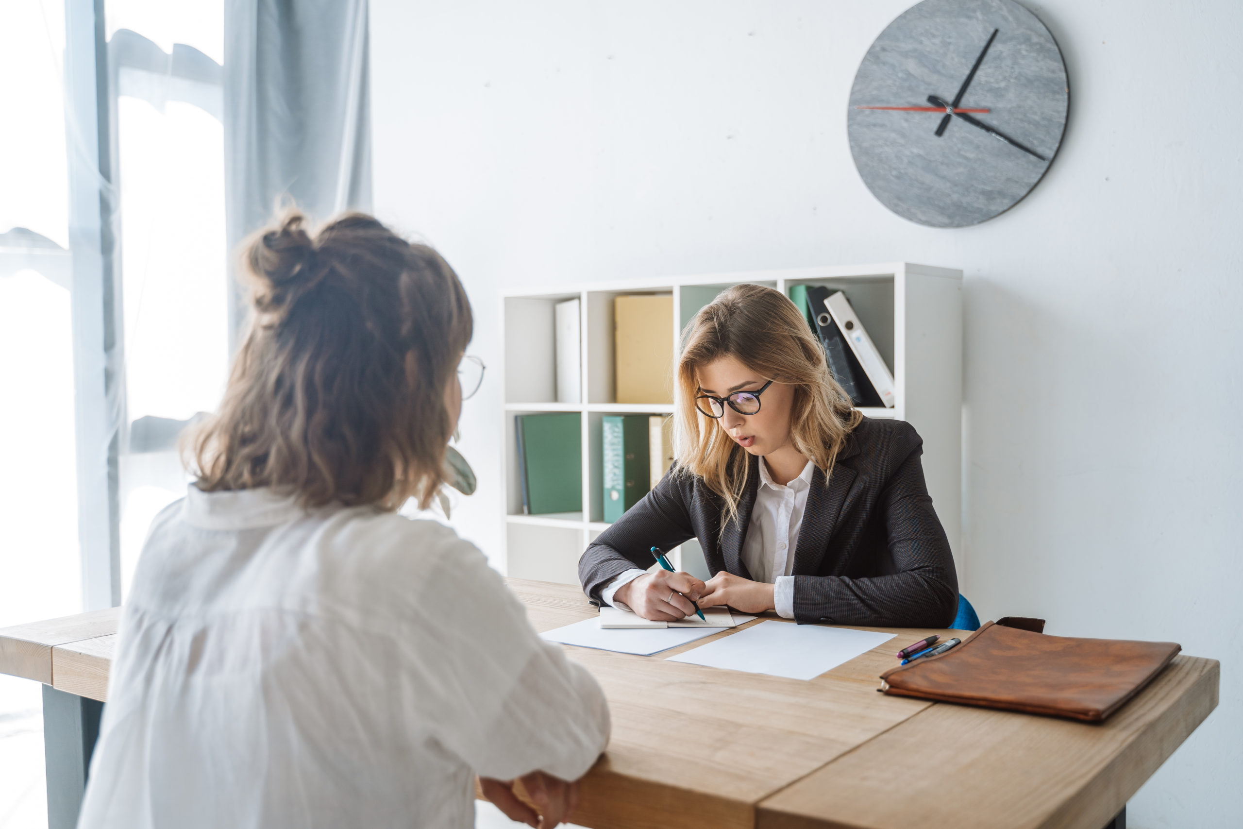 Young female candidate is interviewed by employer businesswoman